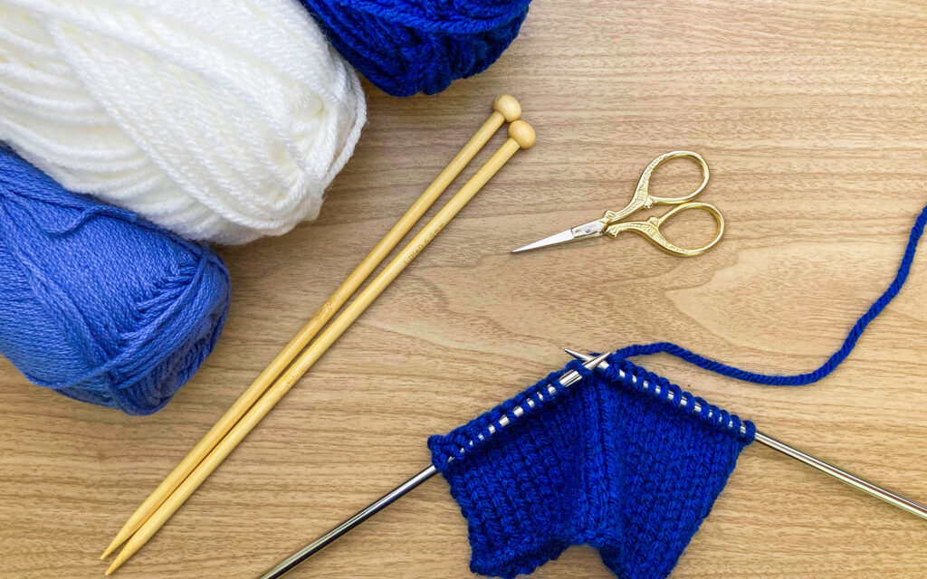 A pair of knitting needles with knitting project in progress